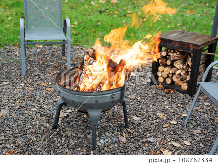 Fire pit and burning fire in a garden Fire pit and burning fire in a garden 108762334