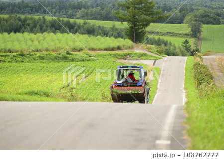 北海道 美瑛 農道を走るトラクター 108762777