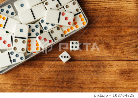 Domino game on brown wooden background close up 108764828