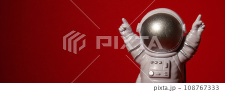 Plastic toy astronaut on colorful red background Copy space. Concept of out of earth travel, private spaceman commercial flights missions and Sustainability Plastic toy astronaut on colorful red background Copy space. Concept of out of earth travel, private spaceman commercial flights missions and Sustainability 108767333