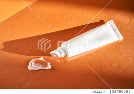 Hygienic moisturizing lip balm in a tube on a orange background. 108769263