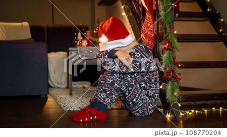 Little upset boy got sad and started crying while waiting for Santa on Christmas eve. Sadness, depression, solitude and negative emotions on winter holidays and New Year. 108770204