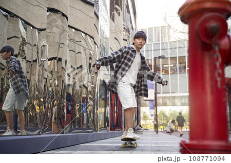 teenage asian child skateboarding outdoors in the street 108771094