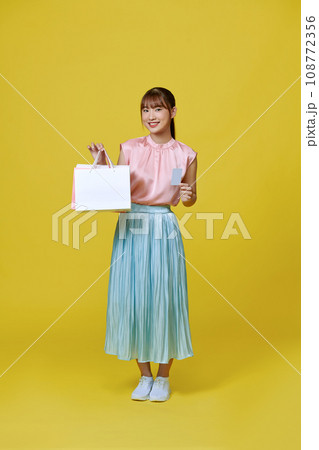 Asian happy female woman girl holds colourful shopping packages and cashless credit card payment Asian happy female woman girl holds colourful shopping packages and cashless credit card payment 108772356
