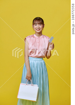 Excited smile Asian woman looking mobile phone holding shopping bag show credit card payment banking shopping online Excited smile Asian woman looking mobile phone holding shopping bag show credit card payment banking shopping online 108772358