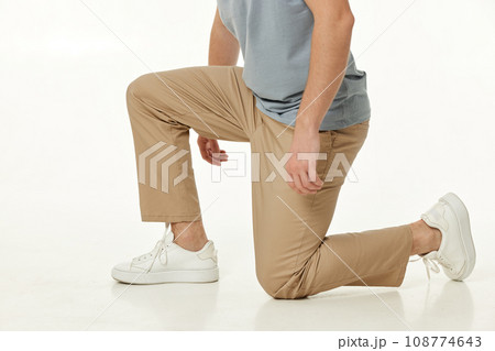 casual man standing on his knees on white studio background casual man standing on his knees on white studio background 108774643