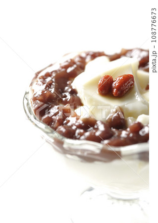 デザートカップに盛り付けられたたっぷりの餡子と杏仁豆腐を白背景で撮影 108776673