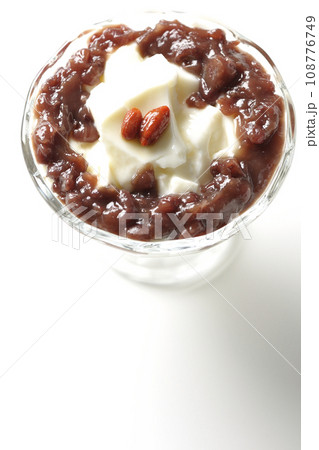 デザートカップに盛り付けられたたっぷりの餡子と杏仁豆腐を白背景で俯瞰撮影 108776749