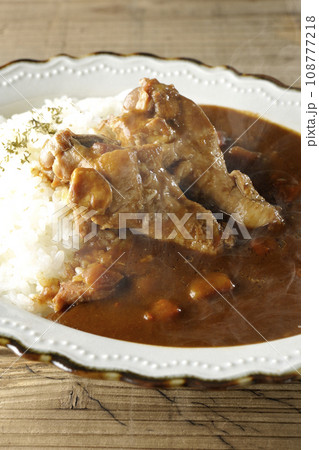 骨付きチキンの入った熱々カレーライス 108777218