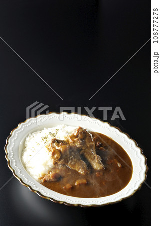 骨付きチキンの入った熱々カレーライスを黒背景で撮影 骨付きチキンの入った熱々カレーライスを黒背景で撮影 108777278