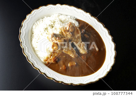 骨付きチキンの入った熱々カレーライスを黒背景で俯瞰撮影 骨付きチキンの入った熱々カレーライスを黒背景で俯瞰撮影 108777344