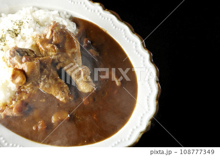 骨付きチキンの入った熱々カレーライスを黒背景で俯瞰撮影 108777349