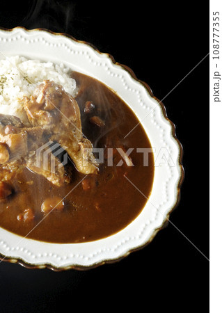 骨付きチキンの入った熱々カレーライスを黒背景で俯瞰撮影 骨付きチキンの入った熱々カレーライスを黒背景で俯瞰撮影 108777355