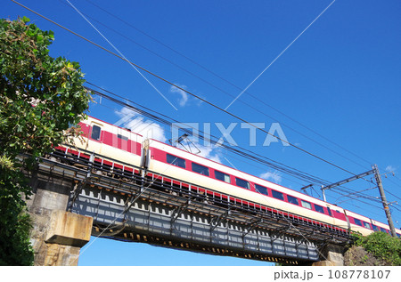 国鉄色のリバイバルカラーに塗装された381系電車の特急やくも号が鉄橋を渡る光景 108778107