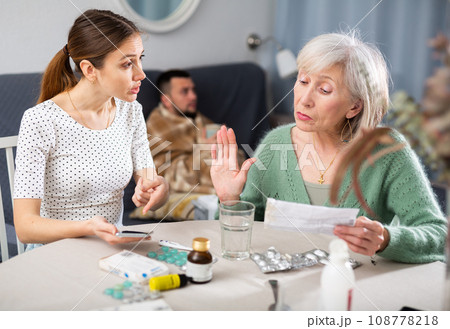 Women choosing medicines for sick adult man Women choosing medicines for sick adult man 108778218
