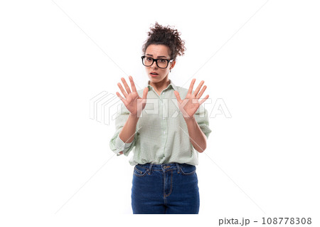 young surprised brunette woman with glasses shows her hands on a white background in copy space young surprised brunette woman with glasses shows her hands on a white background in copy space 108778308