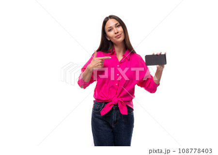 young brunette secretary woman dressed in a pink shirt shows the screen of a mobile phone with a young brunette secretary woman dressed in a pink shirt shows the screen of a mobile phone with a 108778403