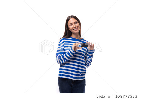 young joyful caucasian woman with dark hair dressed in a blue striped sweatshirt holds a plastic 108778553