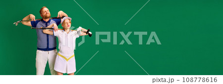 Banner. Father and daughter on golf court. Dad, man and girl, teenager dressed like golf players posing with golf clubs on green background. 108778616