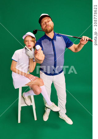 Top view. Father and daughter on golf court. Dad, man and girl, teenager dressed like golf players posing on green background. 108778621