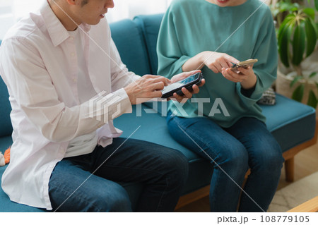 スマホを見る若い男女 108779105
