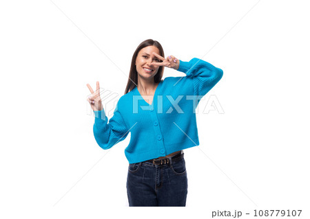 young positive pretty caucasian woman with black hair is dressed in a stylish blue cardigan and 108779107