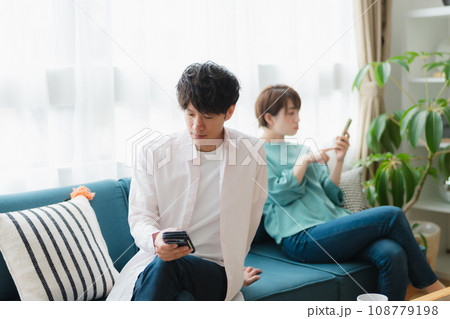 お互いスマホに夢中なカップル お互いスマホに夢中なカップル 108779198