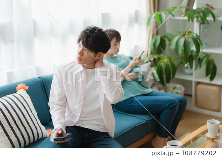 お互いスマホに夢中なカップル お互いスマホに夢中なカップル 108779202