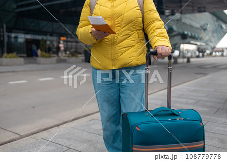 Tourist is waiting a taxi. Senior woman stand outside airport and wait for taxi cab after vacation or travel.  108779778