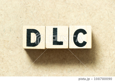 Alphabet letter block in word DLC (abbreviation of downloadable content) on wood background 108780090