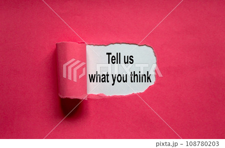 The text 'tell us what you think' appearing behind torn pink paper. 108780203