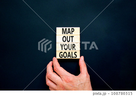 Support and map out your goals symbol. Concept words Map out your goals on wooden blocks on beautiful black table black background. Businessman hand. Business, support and map out your goals concept Support and map out your goals symbol. Concept words Map out your goals on wooden blocks on beautiful black table black background. Businessman hand. Business, support and map out your goals concept 108780315