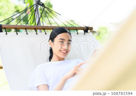 ハンモックでスマホを触る ハンモックでスマホを触る 108781594