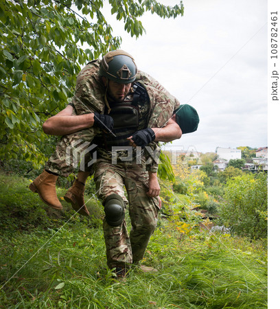 The commander carries a wounded soldier 108782461