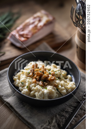 Halusky as traditional Slovak potato gnocchi with sheep cheese bryndza, fried bacon and chives Halusky as traditional Slovak potato gnocchi with sheep cheese bryndza, fried bacon and chives 108782602