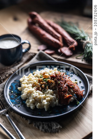 Halusky as traditional Slovak potato gnocchi with sheep cheese bryndza, fried bacon,sausage and chives Halusky as traditional Slovak potato gnocchi with sheep cheese bryndza, fried bacon,sausage and chives 108782606