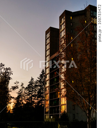 Sunset in a city. High-rise residential building on sunset sky background 108783472