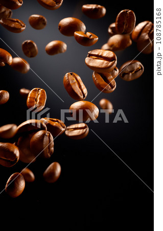 Coffee beans are shown in motion on black background, in the style of dynamic poses. 108785168