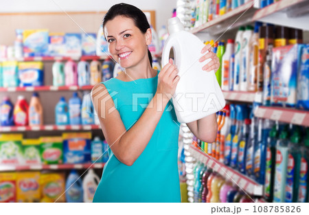 Woman choosing detergent for washing Woman choosing detergent for washing 108785826