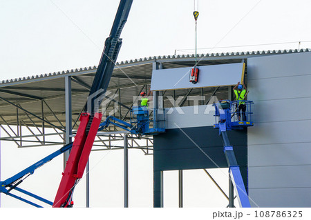 Sandwich panels wall assembly using telescopic boom crane and two self propelled articulating lifts 108786325