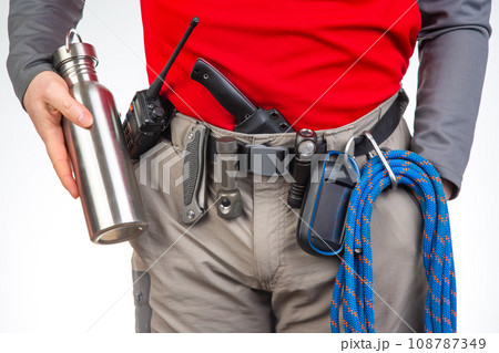 walkie-talkie, flashlight, knife, GPS navigator, climbing rope on the belt of the tourist trekking  108787349