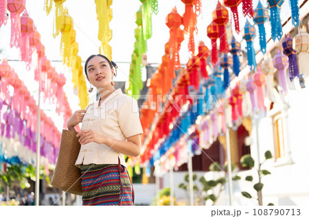 A beautiful Asian-Thai woman in a traditional dress is enjoying in a lantern festival at a temple. 108790713