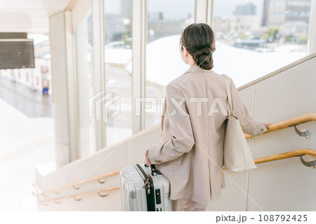 階段で重い荷物を持つ女性（駅・空港） 108792425