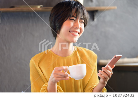 カフェでコーヒーを飲みながらスマホを見る女性 撮影協力「洋菓子店 sentiment」 カフェでコーヒーを飲みながらスマホを見る女性 撮影協力「洋菓子店 sentiment」 108792432