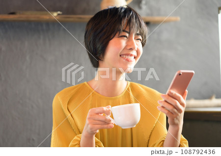 カフェでコーヒーを飲みながらスマホを見る女性　撮影協力「洋菓子店　sentiment」 108792436