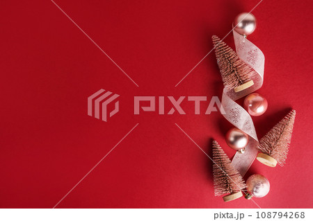 Pink Christmas trees and baubles decoration on red background with copy space. New Year greeting card. Flat lay 108794268