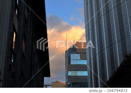 ビルの間から見る夕日にそまる雲 ビルの間から見る夕日にそまる雲 108794872