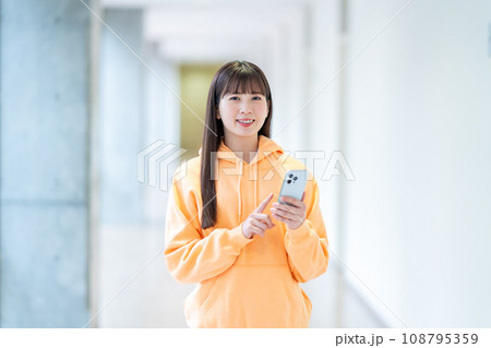 スマホを操作する女子大学生。撮影協力:有明教育芸術短期大学 スマホを操作する女子大学生。撮影協力:有明教育芸術短期大学 108795359