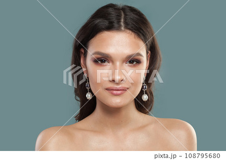Beautiful female face. Brunette woman in jewelry pearl earring, fashion beauty portrait Beautiful female face. Brunette woman in jewelry pearl earring, fashion beauty portrait 108795680