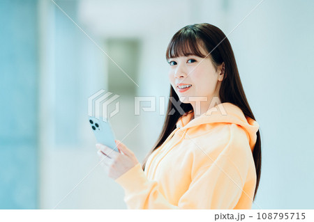 スマホを操作する女子大学生。撮影協力：有明教育芸術短期大学 108795715